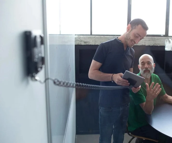 A manager walking a team member through face enrolment on a tablet